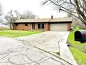 Brick single-story house featuring an attached garage and a spacious front yard at 1761 Country Lane Dr, Greenfield, IN 46140