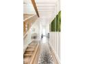Bright hallway featuring wood floors, statement wall decor, and a modern staircase at 1802 Bellefontaine St, Indianapolis, IN 46202