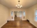 An open living space showcasing hardwood floors, decorative pillars, and a modern chandelier, offering a warm welcome at 2528 E 17Th St, Indianapolis, IN 46218