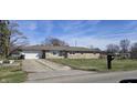 Charming single-story home with a concrete driveway leading to an attached garage at 3002 W 53Rd St, Anderson, IN 46011