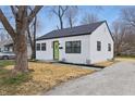 Quaint, updated home featuring white siding, a new roof, black trim and a bright green front door at 3105 N Tacoma Ave, Indianapolis, IN 46218