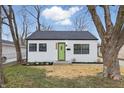 Charming home featuring a new roof, fresh white siding, black trim and a bright green front door at 3105 N Tacoma Ave, Indianapolis, IN 46218