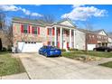 Charming two-story brick home with red shutters, grand white columns, and a well-maintained driveway at 320 Legacy Blvd, Greenwood, IN 46143