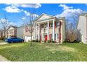 Beautiful two-story home featuring red shutters, grand white columns, and lush green front lawn at 320 Legacy Blvd, Greenwood, IN 46143