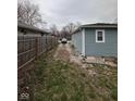 Exterior shot of the back yard with gravel driveway and wooden fence at 3240 Collier St, Indianapolis, IN 46221