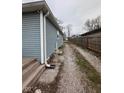 Exterior shot showcasing the side of the home and the gravel driveway at 3240 Collier St, Indianapolis, IN 46221
