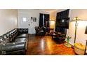 Living room with a dark leather sofa, hardwood floors, and a decorative cactus at 3420 N Chester Ave, Indianapolis, IN 46218