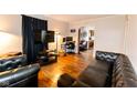 Living room with hardwood floors, a dark leather sofa, and a visible office area at 3420 N Chester Ave, Indianapolis, IN 46218