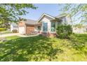 Well-maintained single Gathering home featuring a brick facade, attached garage, and well-maintained front lawn at 377 Van Buren St, Greenfield, IN 46140