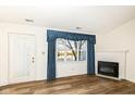 Bright living room featuring laminate floors, fireplace, large windows and backyard pond view at 3818 Gray Pond Ct, Indianapolis, IN 46237