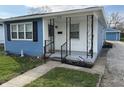 Quaint home featuring a freshly painted blue and white exterior with an inviting front porch at 4121 Fletcher Ave, Indianapolis, IN 46203