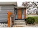 Inviting front entrance with a brick accent, wood door, and a mailbox, creating a warm welcome to the home at 4711 East 21St St, Indianapolis, IN 46218