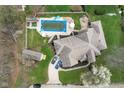 Aerial view of a home featuring a pool, deck, fenced yard, mature trees, and private driveway at 4808 N Camelot Dr, Muncie, IN 47304