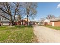 Wide angle of home exterior, showing tree cover, spacious lot, and a long driveway leading up to the attached garage at 6340 Bluebell Ct, Indianapolis, IN 46224