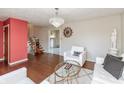Bright living room showcasing a chandelier, large window, hardwood floors, and elegant decor for comfortable living at 6340 Bluebell Ct, Indianapolis, IN 46224