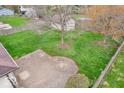 Spacious backyard with green lawn, mature trees and a paved patio area at 66 Coronado Rd, Indianapolis, IN 46234