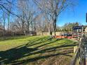 A large backyard featuring lush greenery, a trampoline, and a wooden deck for relaxation at 7211 Kensington Ct, Avon, IN 46123