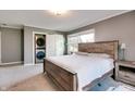 Cozy bedroom with a wood bed frame, carpeted floors, and a stacked washer/dryer in closet at 7525 N Meridian St, Indianapolis, IN 46260