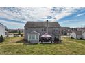 A lovely rear view of a home with a pergola and sunroom, surrounded by a large, green lawn at 8358 Balmoral Dr, Avon, IN 46123