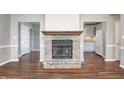 Living room with brick fireplace and views into kitchen with modern white appliances at 901 W 250 N, Lebanon, IN 46052