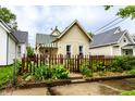 Quaint single-story home showcasing a delightful fenced front yard and established landscaping at 902 Villa Ave, Indianapolis, IN 46203