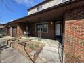 Inviting front porch with brick pillars, a swing, and a view of the landscaped yard at 930 Charlene Ln, Anderson, IN 46011