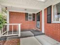 The front porch features classic brickwork and a secure black iron security door at 9406 Northeastern Ave, Indianapolis, IN 46239