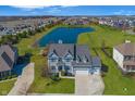 Beautiful aerial view of the home with a pond, lush green lawn, and a view of the neighborhood at 1043 Palomar Dr, Westfield, IN 46074