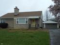 Well-maintained home with stone exterior, detached garage, and a neatly kept front lawn at 1106 N Hartman Dr, Indianapolis, IN 46219
