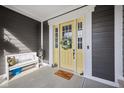Inviting front porch with a bright yellow door, bench, and charming decor accents at 1442 Avondale Dr, Westfield, IN 46074