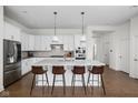 Bright, white kitchen with large center island, modern stainless appliances, and stylish pendant lighting at 15250 Mooring E Cir, Carmel, IN 46033
