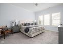 Serene main bedroom featuring calming blue walls, plush carpet, and ample natural light from large windows at 15250 Mooring E Cir, Carmel, IN 46033