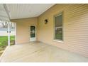 Covered porch with concrete floor and an exterior light fixture at 156 S Cross St, Clayton, IN 46118