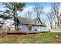 Charming blue home with a deck, white picket fence, and well-maintained lawn on a sunny day at 2025 State Road 47, Lebanon, IN 46052