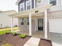 Covered front porch with a brick facade and a black front door at 211 Ames Dr, Whiteland, IN 46184