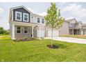 Beautiful two-story home with a well-manicured lawn and a three-car garage at 211 Ames Dr, Whiteland, IN 46184