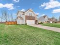 View of the house's side and front, showcasing the lawn and partial brickwork at 2207 Mcgregor Ct, Avon, IN 46123