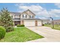 Charming two-story home with manicured lawn, three-car garage, and basketball hoop at 2209 Foxfire Ct, Greenfield, IN 46140
