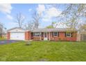 Charming brick ranch with a well-manicured lawn, attached garage and front door decorations at 3104 S Pisgah Way, Columbus, IN 47203