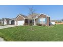 Beautifully landscaped home with a large front yard and blue shutters at 3254 S Ansley Dr, New Palestine, IN 46163