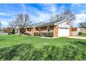 Brick ranch-style home featuring an attached garage and large, well-kept lawn at 3940 E 600 N, Columbus, IN 47203