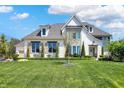 Beautiful two-story home boasts a well-manicured lawn, mature trees, and traditional architectural details at 5130 Melbourne Pl, Zionsville, IN 46077