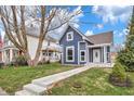 Two-story home with a welcoming front porch and well-manicured lawn on a sunny day at 555 N Hamilton Ave, Indianapolis, IN 46201