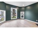 Stylish living room with large windows, hardwood floors, and modern green walls at 555 N Hamilton Ave, Indianapolis, IN 46201