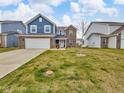 Lovely two-story home with blue siding, brick accents, attached garage, and a green lawn at 5788 Terracotta Trce, McCordsville, IN 46055