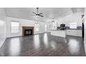 Spacious living room featuring dark wood floors, a ceiling fan, and a cozy fireplace at 6036 Terrytown Pkwy, Indianapolis, IN 46254