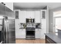 Elegant kitchen featuring white cabinetry, a stainless steel microwave, and a marble backsplash at 634 N Senate Ave, Indianapolis, IN 46202