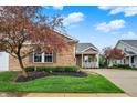 Beautiful brick home with mature trees and manicured landscaping, complemented by a welcoming front porch at 661 Overcup St, Westfield, IN 46074