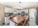 Bright kitchen featuring white cabinets, mosaic backsplash, stainless appliances, and a wood-topped island at 719 Hohlier Ln, Avon, IN 46123