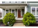 Inviting entryway with a wood door, manicured shrubs, and traditional architectural details at 768 Trailside Dr, Carmel, IN 46032